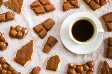 Beyaz arka planda bir fincan siyah espresso kahve ve çikolata, sabah kahve saati.