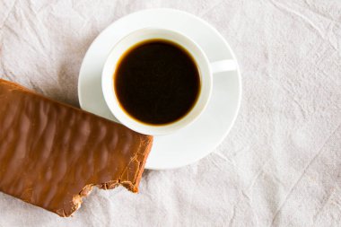 Beyaz arka planda bir fincan siyah espresso kahve ve çikolata, sabah kahve saati.