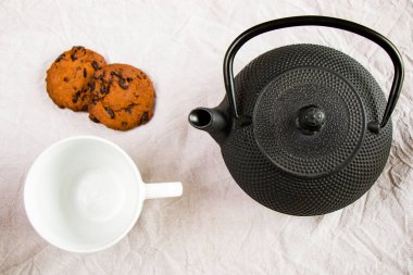 Bir fincan çay, çay ve beyaz örtülü kurabiyeler, sabah yemeği ve içeceği, çikolatalı ve fındıklı tatlı.