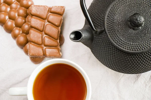 Tasse Tee Eisen Teekanne Und Schokoriegel Auf Dem Weißen Tuch — Stockfoto
