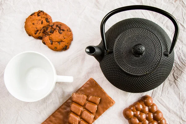 Tasse Tee Eiserne Teekanne Und Kekse Auf Weißem Tuch Hintergrund — Stockfoto