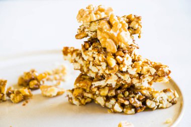 Georgia geleneksel tatlı, fındık ve bal, tabakta Gozinaki, beyaz arka plan.