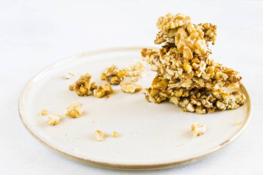 Georgia geleneksel tatlı, fındık ve bal, tabakta Gozinaki, beyaz arka plan.