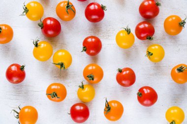 Tüm renkler ve renkli domatesler, yüksek açılı gıda arka planı, kırmızı, sarı ve turuncu renkler.