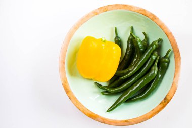 Beyaz arka planda sarı dolma biber ve yeşil biber renkli sebzeler, ham malzemeler.