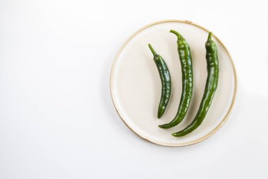 Tabakta yeşil biber, beyaz arka plan ve yüksek açı manzarası.