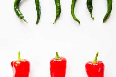 Beyaz arka planda dolmalık biber ve yeşil biber renkli sebzeler, ham malzemeler.