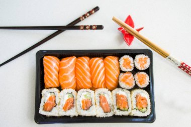 Kaliforniya suşi ruloları siyah kabın içinde, suşi teslimatı seti, yüksek açılı görüş.