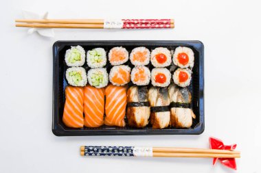 Kaliforniya ve yılan balığı suşi ruloları siyah kabın içinde, suşi teslimatı seti, yüksek açılı görüş.