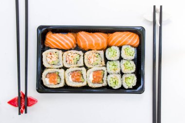 Kaliforniya suşi ruloları siyah kabın içinde, suşi teslimatı seti, yüksek açılı görüş.