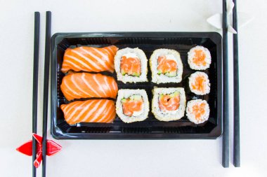 Kaliforniya suşi ruloları siyah kabın içinde, suşi teslimatı seti, yüksek açılı görüş.