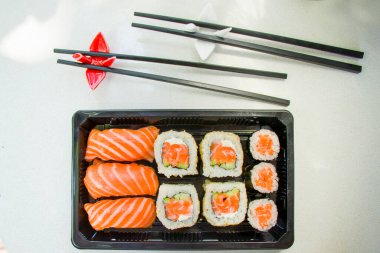 Kaliforniya suşi ruloları siyah kabın içinde, suşi teslimatı seti, yüksek açılı görüş.