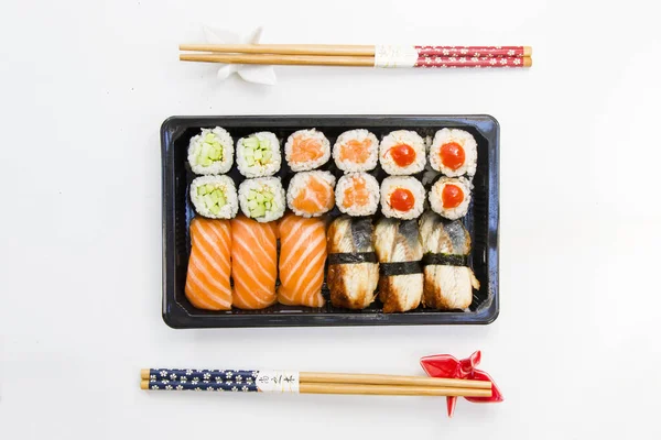 Kaliforniya ve yılan balığı suşi ruloları siyah kabın içinde, suşi teslimatı seti, yüksek açılı görüş.