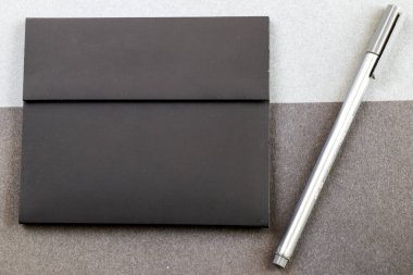 Siyah ve gri kağıtlarda gri kalem ve siyah harf zarfı. Arka plan ve doku, gri eğimli.