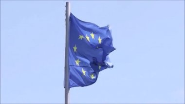 Mavi gökyüzünde Avrupa Birliği bayrağının, yıldızların ve mavi rengin videosu. Rüzgarda hareket eden bayrağın yakın çekimi, Tiflis, Georgia 'da rüzgarlı hava.