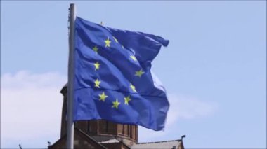 Mavi gökyüzünde Avrupa Birliği bayrağının, yıldızların ve mavi rengin videosu. Rüzgarda hareket eden bayrağın yakın çekimi, Tiflis, Georgia 'da rüzgarlı hava.