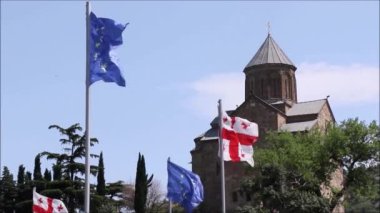 Mavi gökyüzünde Avrupa Birliği bayrağının, yıldızların ve mavi rengin videosu. Rüzgarda hareket eden bayrağın yakın çekimi, Tiflis, Georgia 'da rüzgarlı hava.