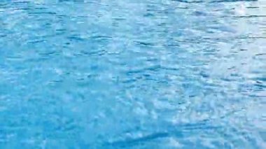 Yüzme havuzu suyu, su yansıması ve güneş ışığı. Açık hava ve gün ışığı. Su taşıma sahnesi.