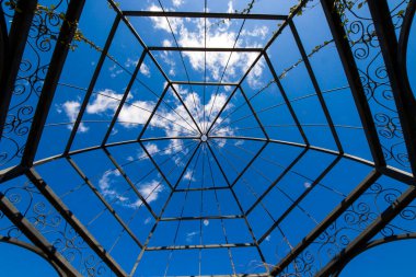 Tiflis 'teki mavi gökyüzü arka planındaki parkta demir ve metal yapı