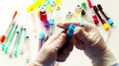Kan testi örnekleri, tüp ve kan testi için iğne ve eldivenli doktorlar.