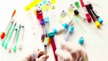 Kan testi örnekleri, tüp ve kan testi için iğne ve eldivenli doktorlar.