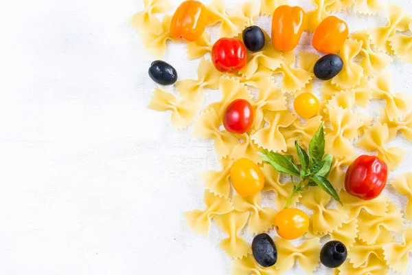 Pasta Ingrediënten Rauwe Pasta Kerstomaten Olijven Basilicum Bladeren Witte Achtergrond — Stockfoto