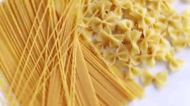 Beyaz arka planda çiğ makarna ve spagetti.