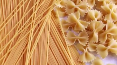 Beyaz arka planda çiğ makarna ve spagetti.