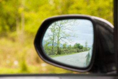 Araba aynasında yol ve ağaçlar