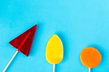 Renkli şekerler, mavi arka planda lolipop, çok renkli.