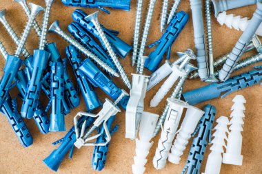 Kahverengi arkaplan ve yüksek açı görünümünde geniş bir duvar eklentisi ve vidaları grubu