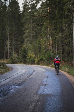 Orman yolunda giden bir bisikletçi.