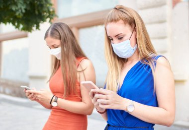 İki bin yıllık tıp maskesi takan ve sosyal mesafeyi koruyan kızlar sosyal medyada hikayelerini paylaşırlar.