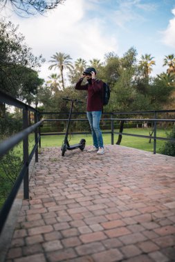 Çocuk işe gitmeden önce kaskını elektrikli scooterına takıyor..