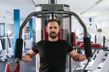 Spor salonundaki makinede çalışan bir adam. Ona odaklan..