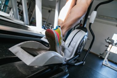 Genç erkek eliptik kullanıyor. Sağlık ve refah kavramı..