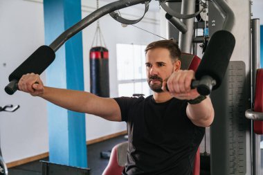 Spor salonundaki makinede çalışan bir adam. Ona odaklan..