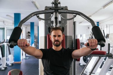 Spor salonundaki makinede çalışan bir adam. Ona odaklan..