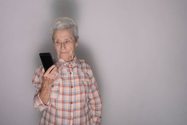 Büyükannem cep telefonundan konuşuyor. Teknoloji, iletişim ve yaşlılar konsepti.