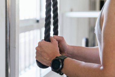 Spor salonunda iple triseps yapan adam. İp ve egzersiz kavramı..