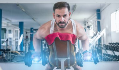 Spor salonunda uzanmış kol egzersizi yapan bir adam. Kameraya bakıyorum. Sağlık ve Sıhhat kavramı