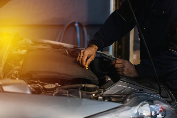 Zbliżenie Mechanika Samochodowego Sprawdzającego Poziom Oleju Warsztacie Mechanicznym — Zdjęcie stockowe