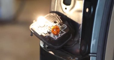 Tamirci araba atölyesinde araba lambasını değiştiriyor. Otomotiv konsepti. 4k