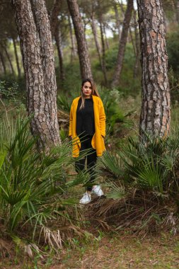 Sarı ceketli ve şapkalı bir kadın. Sıradan moda..