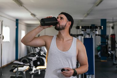 Erkek sporcu protein içeceği içiyor.