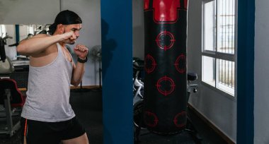 Spor salonunda kum torbası yumruklayan bir adam. Spor salonu.