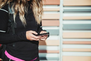 Açık havada egzersiz yaptıktan sonra telefonu kullanan tanınmamış sporcu kadın. Güzel kadın. Spor Konsepti