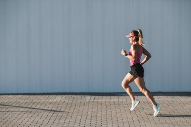 Şehirde koşuşturan güzel genç bir koşucu.