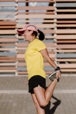 Sokakta esneme hareketleri yapan genç bir kadın.