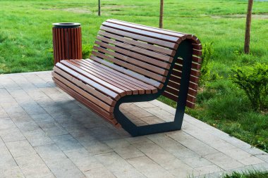 Modern park bankı ve tahtadan yapılmış çöp tenekesi